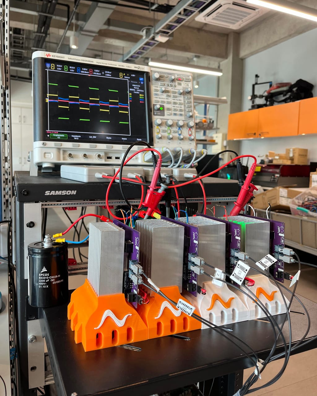 Four converter modules on heatsinks wired to an oscilloscope on the bench