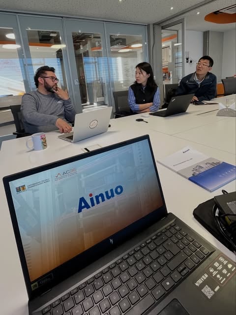 Meeting with the Ainuo team around a laptop showing their presentation